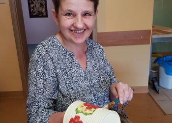 Powiększ zdjęcie: podopieczna prezentuje pracę wykonaną techniką decoupage w pracowni batiku i papieru