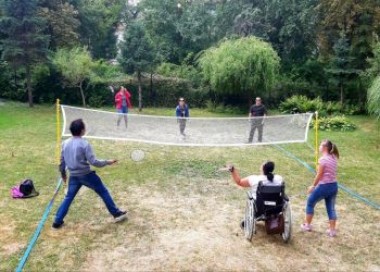 Powiększ zdjęcie: podopieczni grają przez siatkę w badmintona w ogrodzie