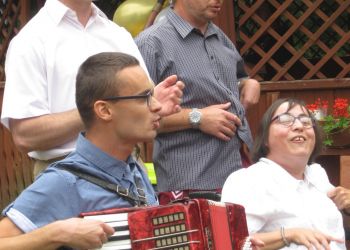 Powiększ zdjęcie: podopieczny grający na akordeonie w towarzystwie śpiewających kolegów i koleżanki
