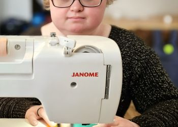 Powiększ zdjęcie: uczestniczka zajęć szyje na maszynie